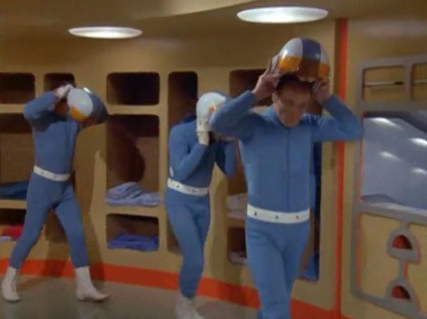 Moonbase - The scene when interceptor pilots slide down the tubes to reach their cockpits – is one of the most famous and beloved moments in retro sci-fi history. Battlestar Galactica (both the original 1978 version and the famous 2004 reboot) "borrowed" that exact concept!
The Low-Tech "Tube" Illusion - The sequence you are smiling about is a perfect example of how the British crew used pure physical tricks instead of expensive technology to make something look highly cool. Sometimes they succeeded, somethimes failed.
The Look - When the alien alarm rings, the three pilots jump out of their blue zipper-pyjama uniforms and slide feet-first down these bright metal chutes. The camera cuts, and suddenly they are sitting perfectly upright in their spaceship seats, ready to launch.
The Reality - There were no complex mechanics. The actors literally just sat on playground-style metal slides in the studio. They slid down into a mattress on the floor out of frame. Then, the camera would cut to a completely different set where they were already strapped into the cockpits. It was cheap, simple, and looked incredibly futuristic for 1970.
It Shaped Modern Sci-Fi
When Battlestar Galactica came out later, the American creators copied this exact pacing. They took that thrilling, fast-paced sequence of pilots scrambling from their quarters, jumping into launch tubes, and shooting out into space in their Viper fighters. By combining the glamorous, stylish lifestyle of the base with the gritty, mechanical reality of the pilots, UFO created the blueprint for how modern sci-fi handles military organizations in space.
It proved that you can have a show that is deeply focused on high-tech military strategy, while still ensuring the background is filled with enough visual style and glamour to keep the audience under that "hypnotic screen" spell.
The Contrast - Moonbase Beauties vs. The Boys' Club
The way the show balanced sex appeal with this "advanced space team" is where the corporate logic gets really funny. On one side of the Moonbase, you have the female officers wearing heavy makeup, purple hair, and tight silver miniskirts. They are the ones tracking the alien radar and typing on the computers. But the moment a real fight starts, the show shifts to the three male pilots in their blue pajamas and matching silver motorcycle helmets.
It was a total reflection of 1970 society. The creators wanted the high-fashion, liberal visual hook of the "Moonbase Beauties" to get people to watch the screen, but when it came to the actual space battles, they reverted back to a traditional, serious military setup. The pilots didn't look sexy or futuristic – they looked like a highly trained bobsled team or racecar drivers.